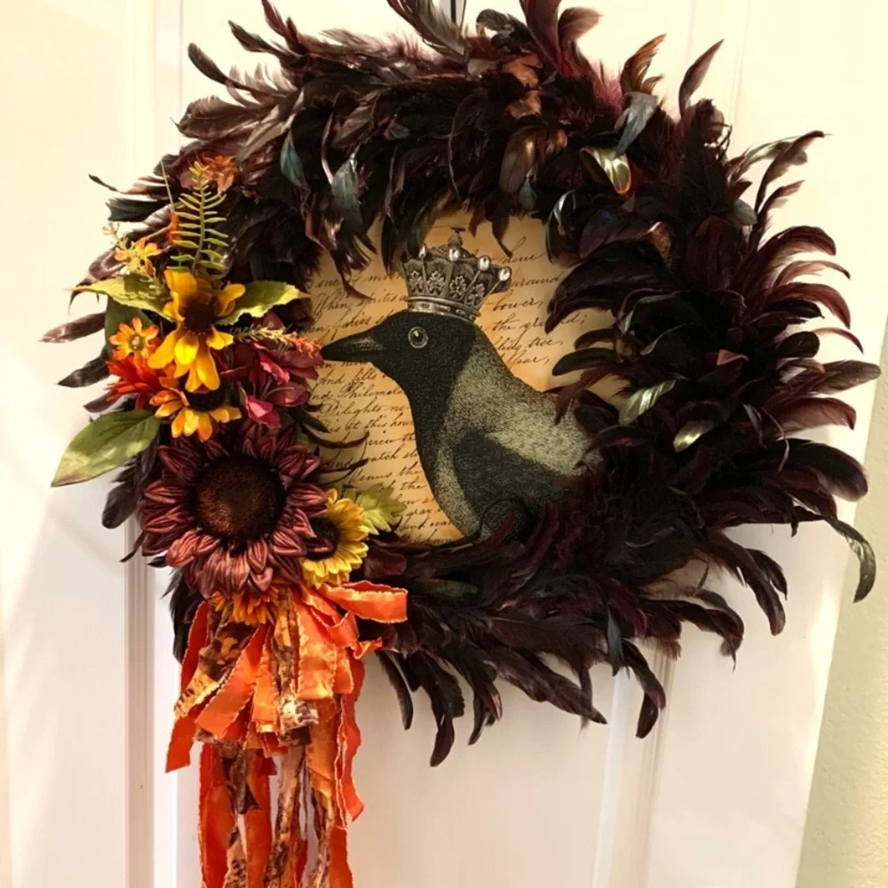 Dark red and black feather wreath with fall floral and a crowned crow center